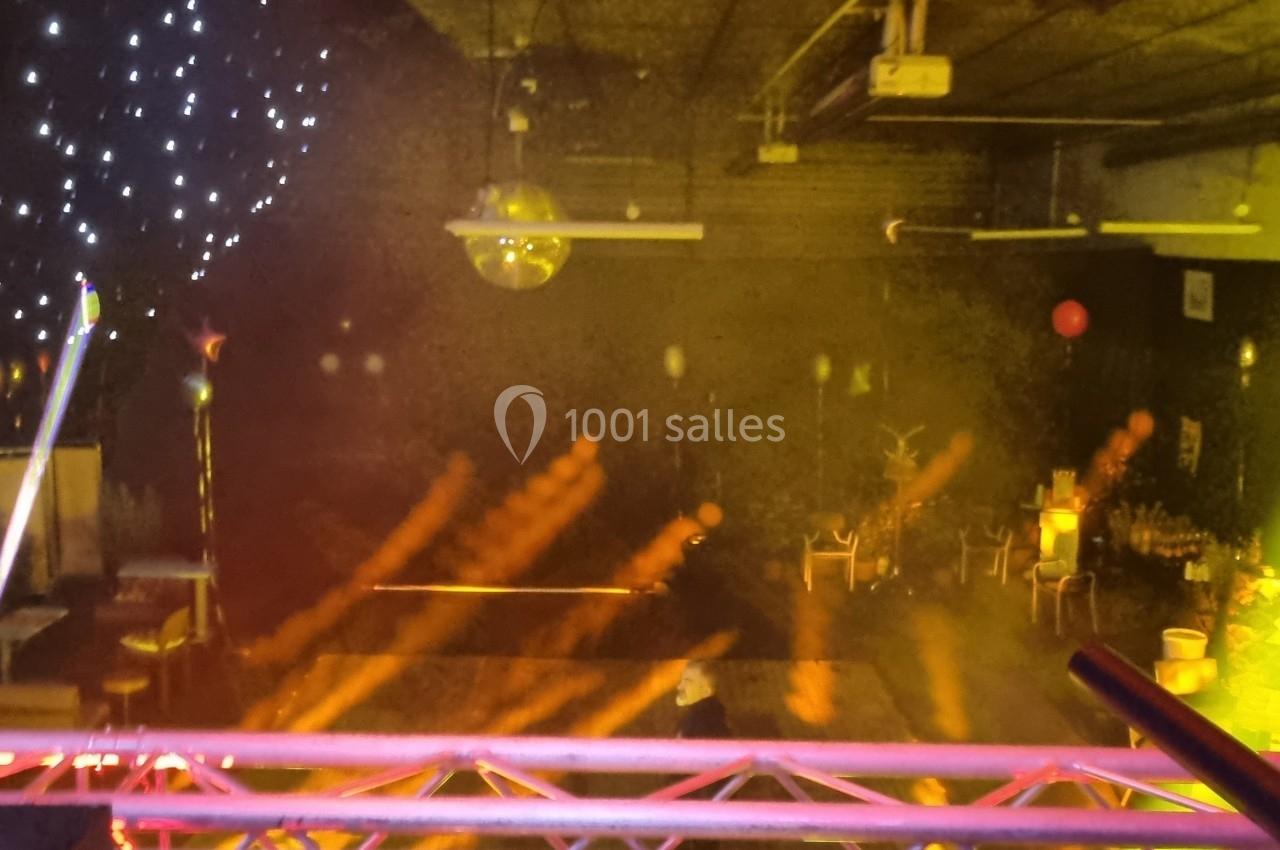 Salle de réception avec éclairage coloré, projecteurs, décorations lumineuses et ambiance festive.