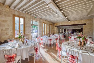 Table dressée avec des verres, tasses à café, un menu, un ordinateur portable ouvert et des chandeliers en arrière-plan.