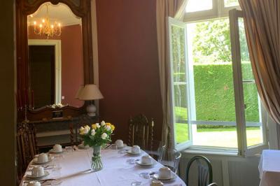 Table dressée avec des verres, tasses à café, un menu, un ordinateur portable ouvert et des chandeliers en arrière-plan.