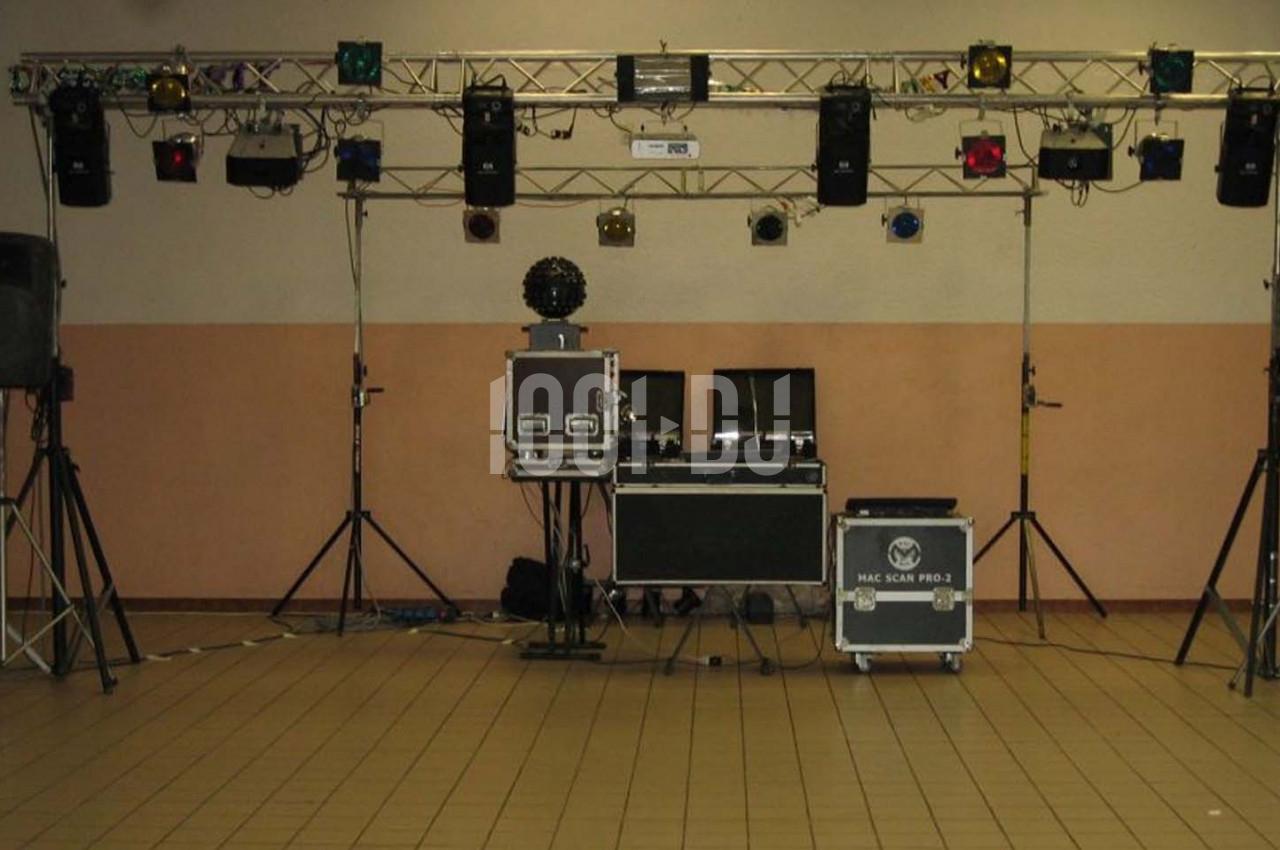 Équipement de sonorisation et éclairage installé dans une salle avec carrelage et murs clairs.