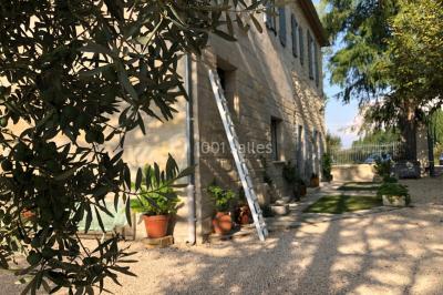 Salle de bain avec douche à l'italienne, lavabo double vasque, miroir éclairé et toilettes sur carrelage en terre cuite.