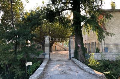 Salle de bain avec douche à l'italienne, lavabo double vasque, miroir éclairé et toilettes sur carrelage en terre cuite.