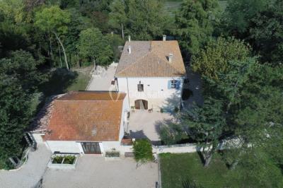 Salle de bain avec douche à l'italienne, lavabo double vasque, miroir éclairé et toilettes sur carrelage en terre cuite.