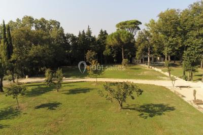 Salle de bain avec douche à l'italienne, lavabo double vasque, miroir éclairé et toilettes sur carrelage en terre cuite.