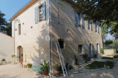 Salle de bain avec douche à l'italienne, lavabo double vasque, miroir éclairé et toilettes sur carrelage en terre cuite.