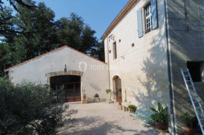 Salle de bain avec douche à l'italienne, lavabo double vasque, miroir éclairé et toilettes sur carrelage en terre cuite.