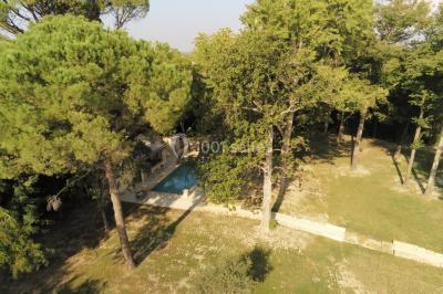 Salle de bain avec douche à l'italienne, lavabo double vasque, miroir éclairé et toilettes sur carrelage en terre cuite.