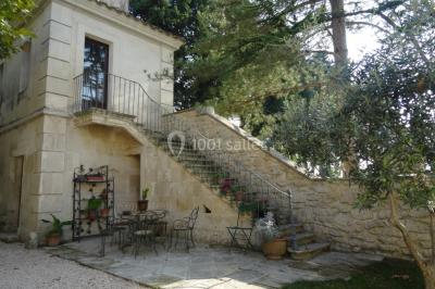Salle de bain avec douche à l'italienne, lavabo double vasque, miroir éclairé et toilettes sur carrelage en terre cuite.