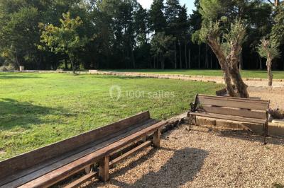 Salle de bain avec douche à l'italienne, lavabo double vasque, miroir éclairé et toilettes sur carrelage en terre cuite.