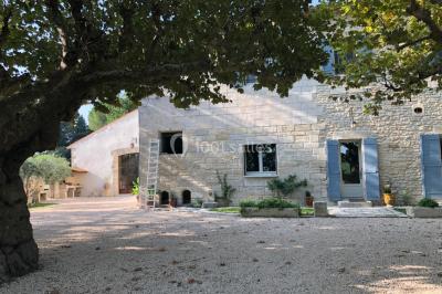 Salle de bain avec douche à l'italienne, lavabo double vasque, miroir éclairé et toilettes sur carrelage en terre cuite.