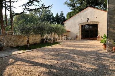 Salle de bain avec douche à l'italienne, lavabo double vasque, miroir éclairé et toilettes sur carrelage en terre cuite.