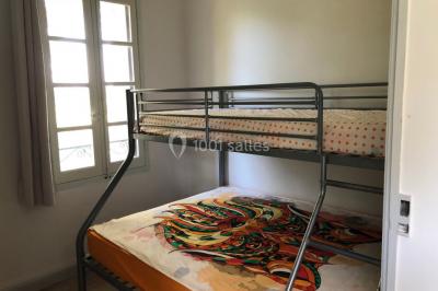 Salle de bain avec douche à l'italienne, lavabo double vasque, miroir éclairé et toilettes sur carrelage en terre cuite.
