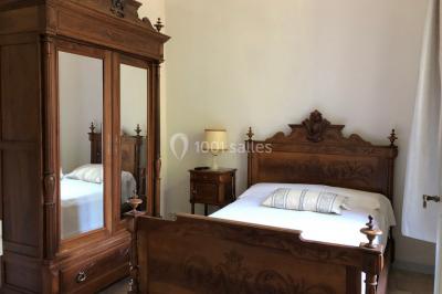 Salle de bain avec douche à l'italienne, lavabo double vasque, miroir éclairé et toilettes sur carrelage en terre cuite.