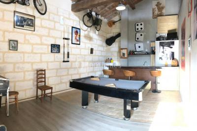 Salle de bain avec douche à l'italienne, lavabo double vasque, miroir éclairé et toilettes sur carrelage en terre cuite.