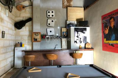 Salle de bain avec douche à l'italienne, lavabo double vasque, miroir éclairé et toilettes sur carrelage en terre cuite.