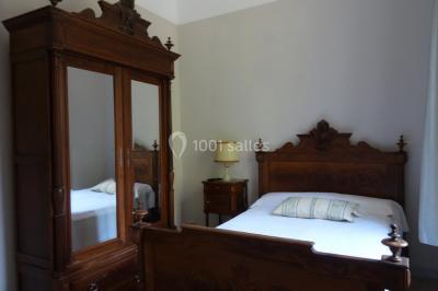 Salle de bain avec douche à l'italienne, lavabo double vasque, miroir éclairé et toilettes sur carrelage en terre cuite.