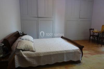 Salle de bain avec douche à l'italienne, lavabo double vasque, miroir éclairé et toilettes sur carrelage en terre cuite.