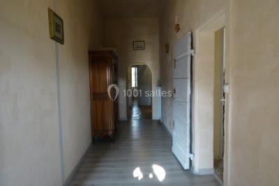 Salle de bain avec douche à l'italienne, lavabo double vasque, miroir éclairé et toilettes sur carrelage en terre cuite.