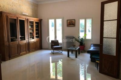 Salle de bain avec douche à l'italienne, lavabo double vasque, miroir éclairé et toilettes sur carrelage en terre cuite.