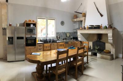Salle de bain avec douche à l'italienne, lavabo double vasque, miroir éclairé et toilettes sur carrelage en terre cuite.
