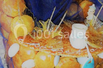 Pièce montée en choux caramélisés décorée de filets bleus, de sucre tiré et d'éléments en pâte d'amande.