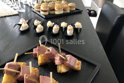 Assortiment de verrines sucrées avec mousse, caramel, mangue et chantilly, disposées sur un plateau noir.