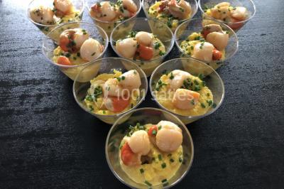 Assortiment de verrines sucrées avec mousse, caramel, mangue et chantilly, disposées sur un plateau noir.