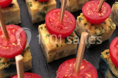 Fontaines de chocolat entourées de fruits frais, guimauves et brochettes sur une table de buffet.