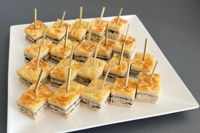 Trois salades colorées présentées dans des bols noirs, composées de légumes variés et décorées de radis sculptés.