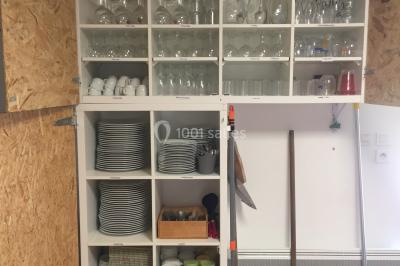 Chaise en bois marquée ’Gîte de la Barre’ dans un jardin verdoyant près d'une maison en pierre et crépi.