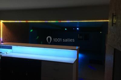 Chaise en bois marquée ’Gîte de la Barre’ dans un jardin verdoyant près d'une maison en pierre et crépi.