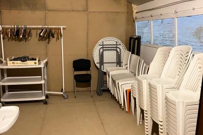 Chaise en bois marquée ’Gîte de la Barre’ dans un jardin verdoyant près d'une maison en pierre et crépi.