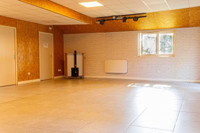 Chaise en bois marquée ’Gîte de la Barre’ dans un jardin verdoyant près d'une maison en pierre et crépi.