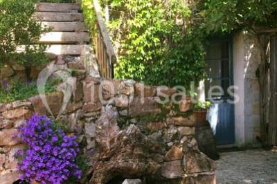 Salle de réception décorée avec des tables dressées, nappes blanches, chaises ajourées et compositions florales.