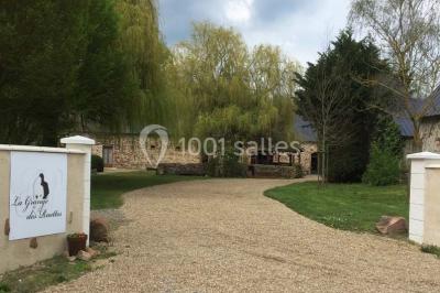 Salle de réception décorée avec des tables dressées, nappes blanches, chaises ajourées et compositions florales.
