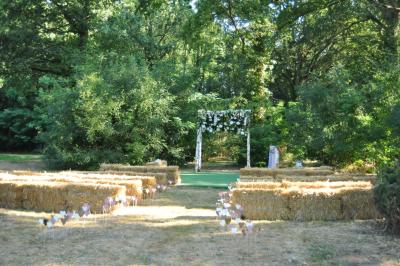 Salle de réception décorée avec des tables dressées, nappes blanches, chaises ajourées et compositions florales.