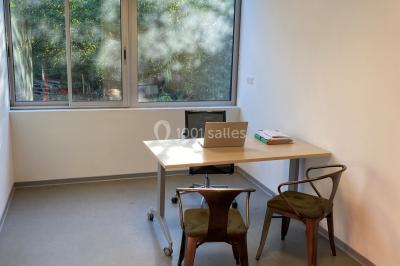 Scène vide éclairée par des projecteurs colorés dans une salle sombre avec un sol en béton.