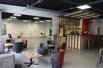 Scène vide éclairée par des projecteurs colorés dans une salle sombre avec un sol en béton.