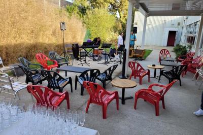Scène vide éclairée par des projecteurs colorés dans une salle sombre avec un sol en béton.
