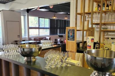 Scène vide éclairée par des projecteurs colorés dans une salle sombre avec un sol en béton.