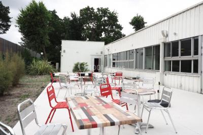 Salle vide avec sol en béton, murs sombres, éclairage au plafond et une table de mixage au fond.