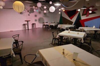 Salle vide avec sol en béton, murs sombres, éclairage au plafond et une table de mixage au fond.