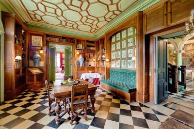 Un stand culinaire en plein air avec des chefs préparant des plats, entouré de fleurs et d'une structure en bois.