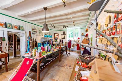 Un stand culinaire en plein air avec des chefs préparant des plats, entouré de fleurs et d'une structure en bois.