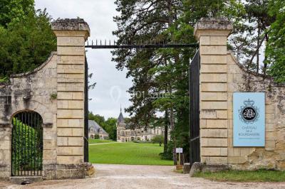 Un stand culinaire en plein air avec des chefs préparant des plats, entouré de fleurs et d'une structure en bois.