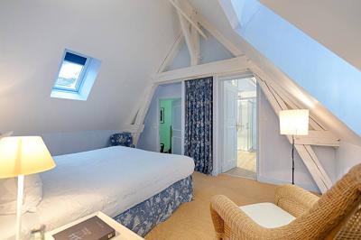 Un stand culinaire en plein air avec des chefs préparant des plats, entouré de fleurs et d'une structure en bois.