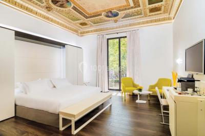 Salle de bain moderne avec douche vitrée, lavabo blanc, miroir rond, fleurs jaunes et mur bleu texturé.