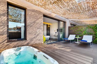 Salle de bain moderne avec douche vitrée, lavabo blanc, miroir rond, fleurs jaunes et mur bleu texturé.