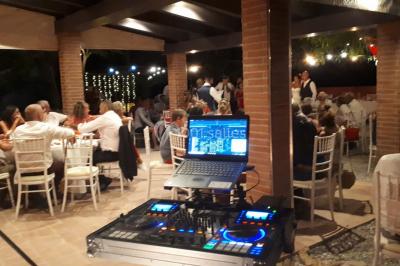Salle de réception décorée avec des lumières colorées, des lanternes suspendues et un espace pour la musique et la danse.