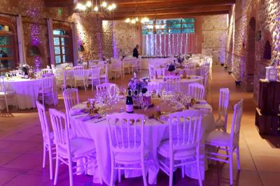 Salle de réception décorée avec des lumières colorées, des lanternes suspendues et un espace pour la musique et la danse.